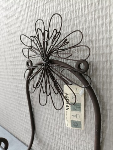Close-up van het fijnmazige bruine bloemdesign en de industriële afwerking van de metalen toiletrolhouder