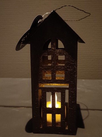 Metalen waxine huisje ALMU met brandend waxinelichtje waardoor een warme lichtgloed ontstaat