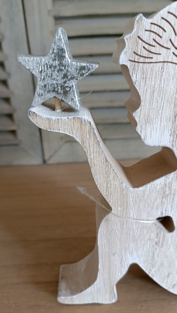 Zittend engeltje met ster op de hand dichtbij