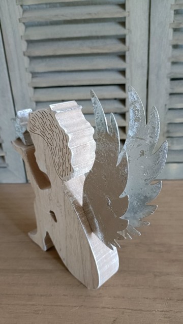 Zittend engeltje met ster op de hand schuin van achteren